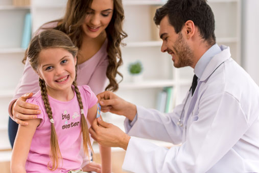 Young girl gets a bandaid after visiting doctor.